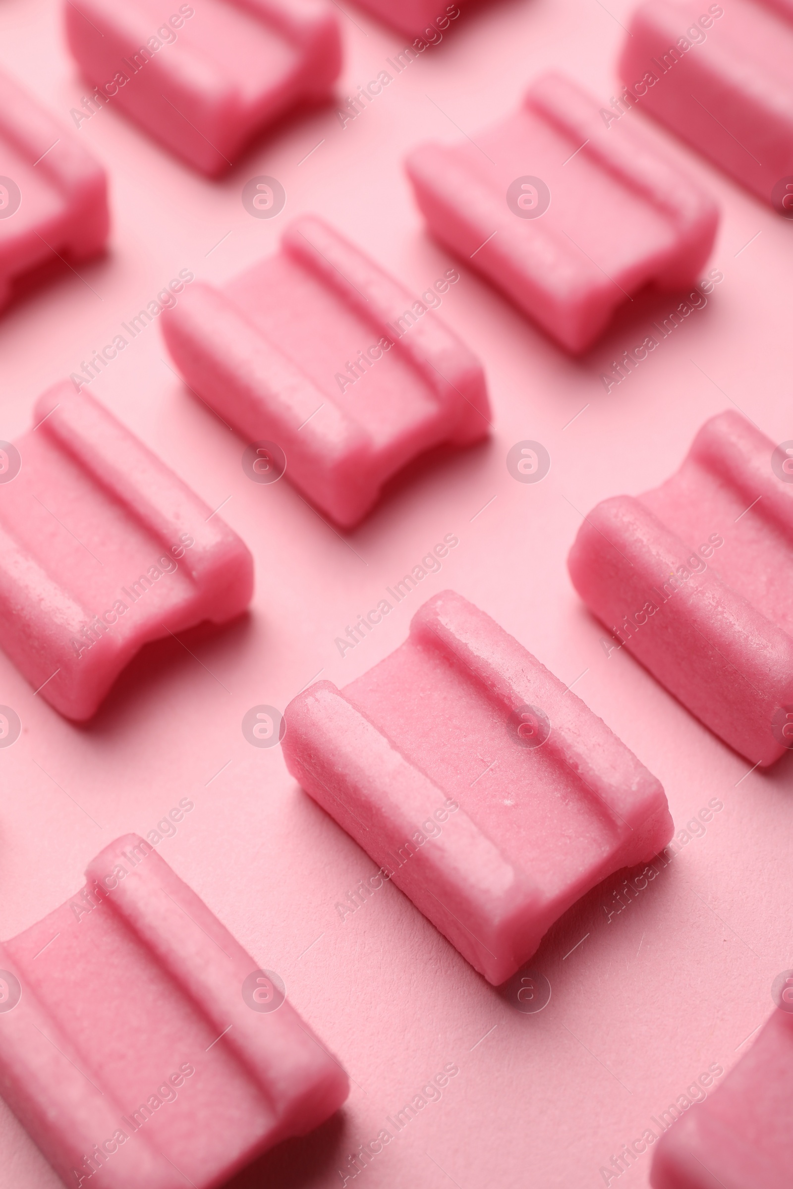 Photo of Tasty chewing gums on pink background, closeup