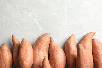 Photo of Flat lay composition with sweet potatoes and space for text on light background