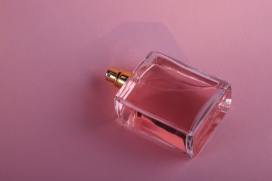 Luxury women's perfume in bottle on violet background