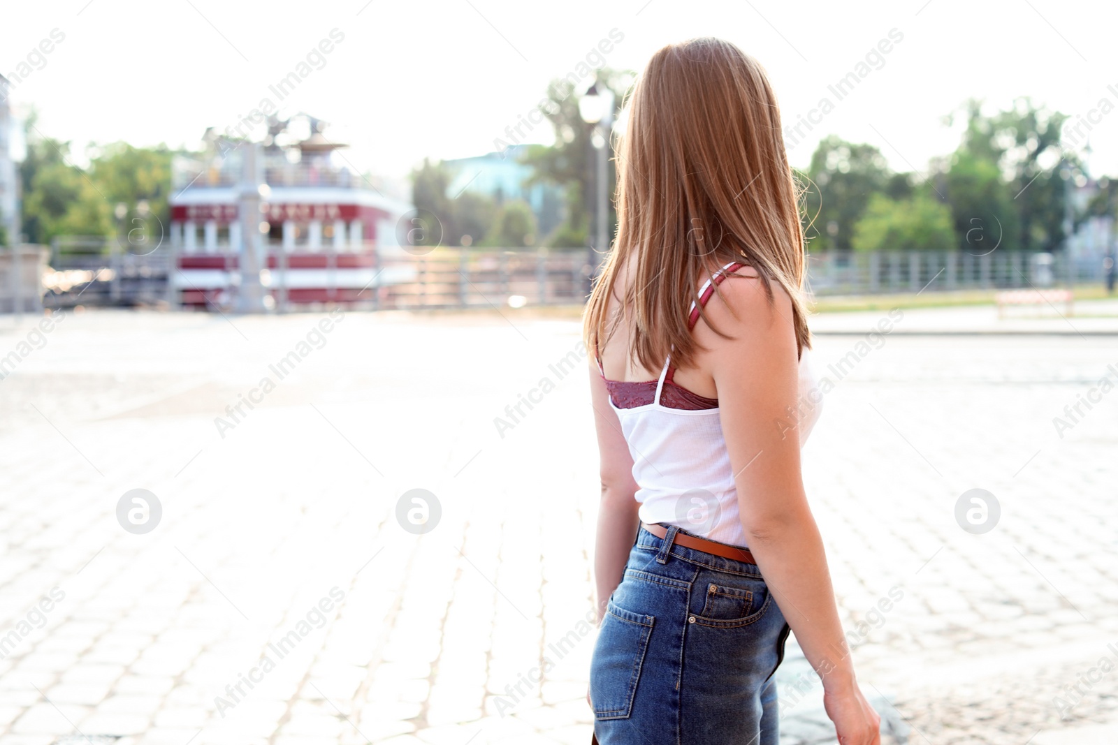 Photo of Young woman in casual clothes on city street