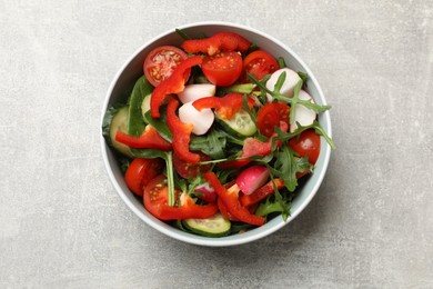 Photo of Tasty fresh vegetarian salad on light grey table, top view