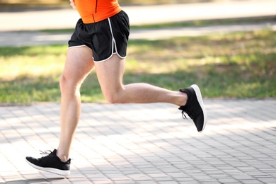 Young man running in park on sunny day