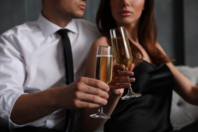 Photo of Beautiful couple with glasses of champagne indoors, closeup. Luxury lifestyle