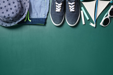 Photo of Different child accessories and space for text on green chalkboard, flat lay. School holidays