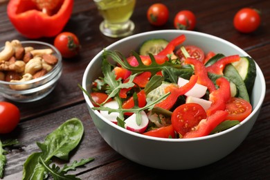 Photo of Tasty fresh vegetarian salad on dark wooden table