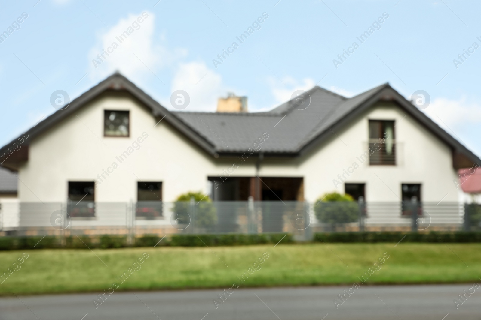 Photo of Blurred view of beautiful house behind fence