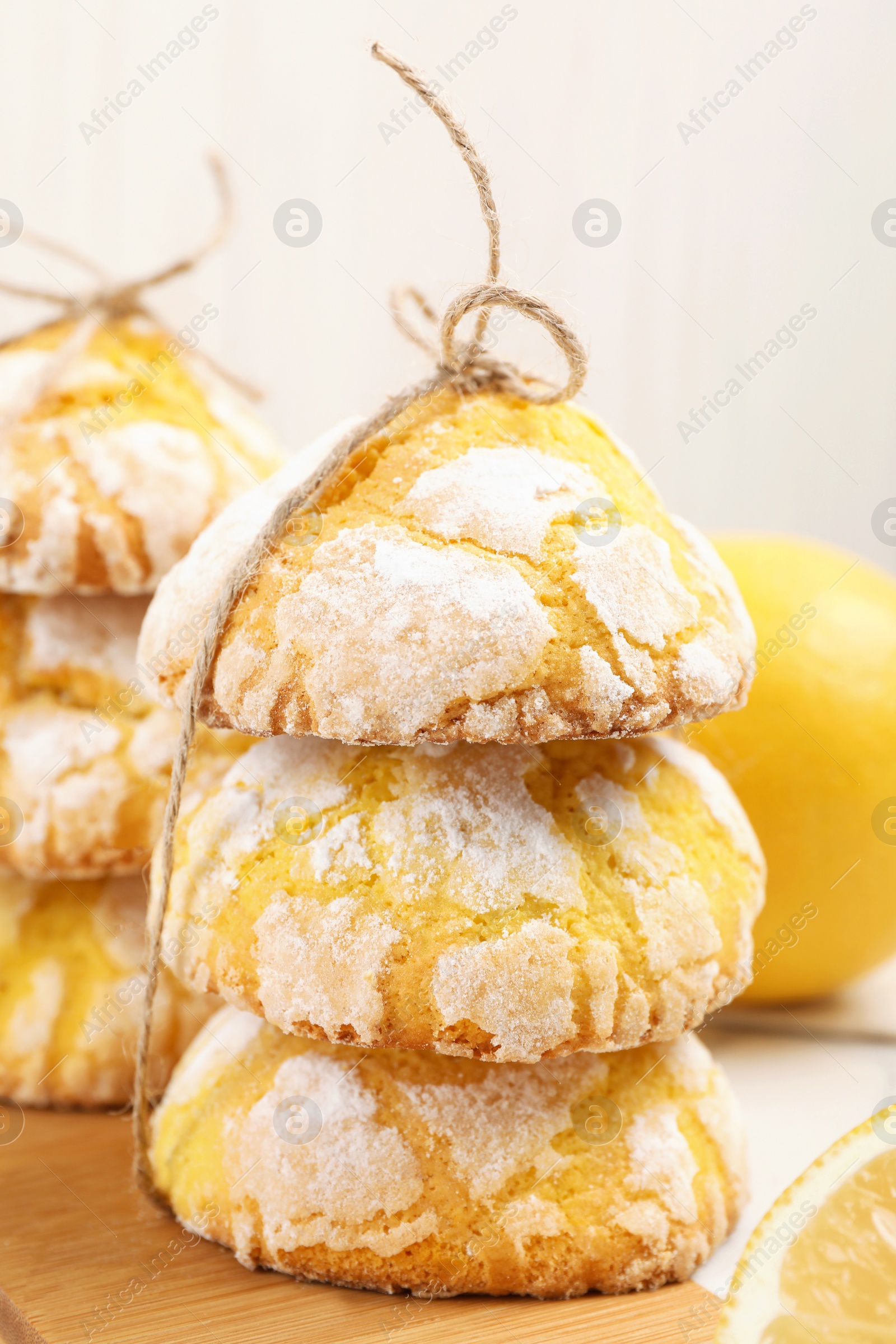 Photo of Tasty homemade lemon cookies on wooden board, closeup