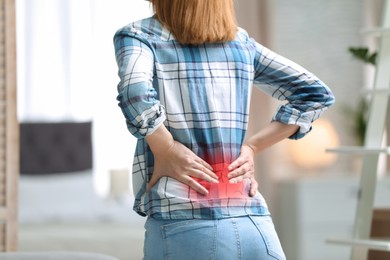 Image of Woman suffering from pain in lower back at home, closeup