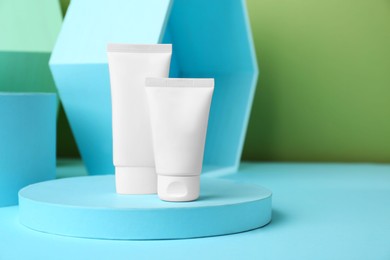 Photo of Composition with tubes of hand cream on light blue table, space for text