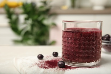 Glass with delicious acai smoothie on table, closeup