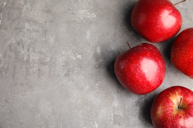 Photo of Ripe juicy red apples on grey background, flat lay. Space for text