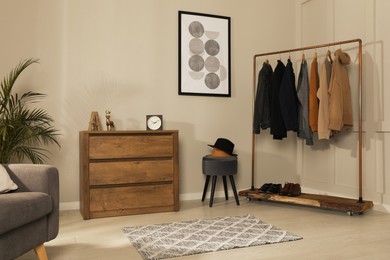 Photo of Modern dressing room interior with stylish clothes, shoes and decorative elements