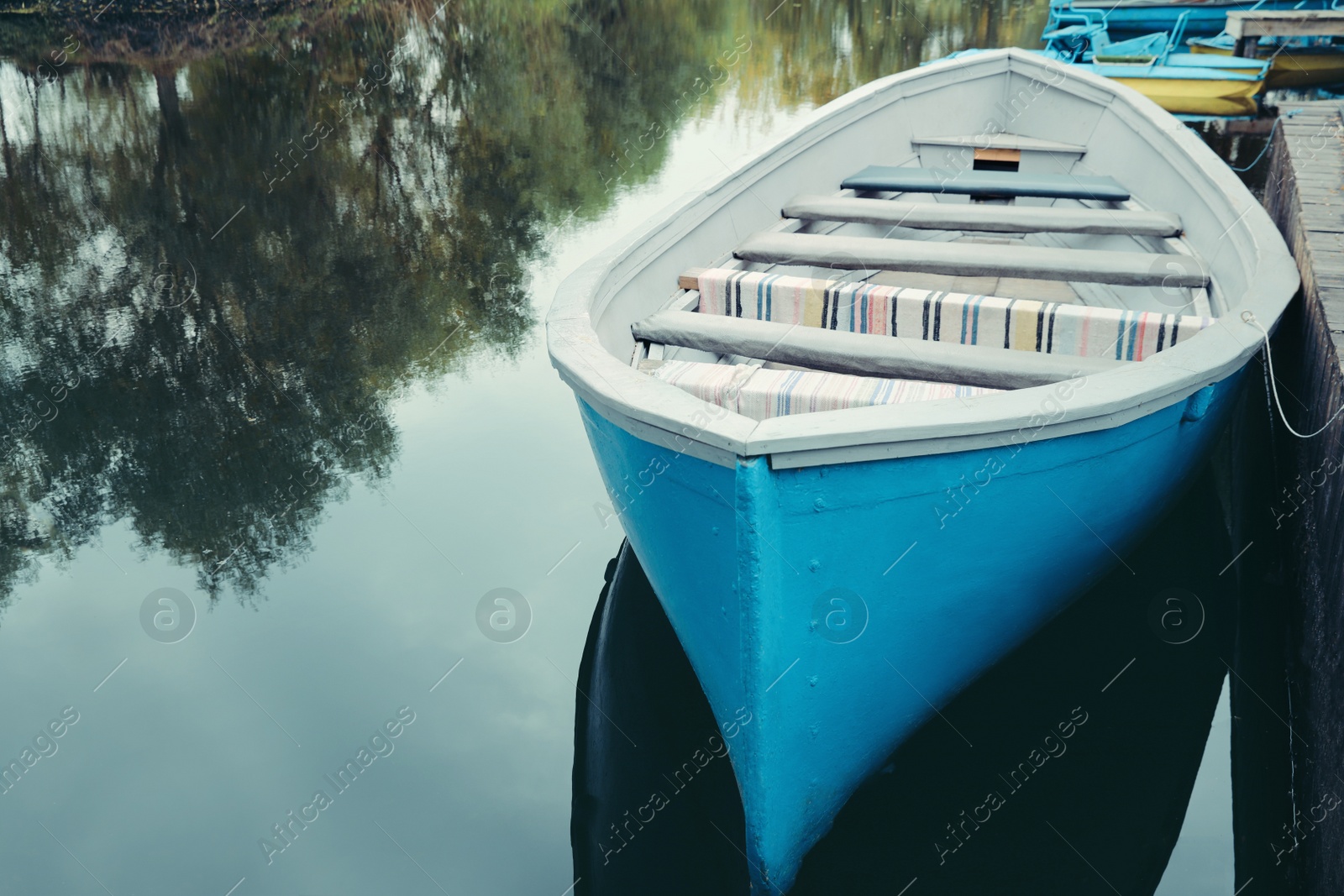 Photo of Light blue wooden boat on lake, space for text
