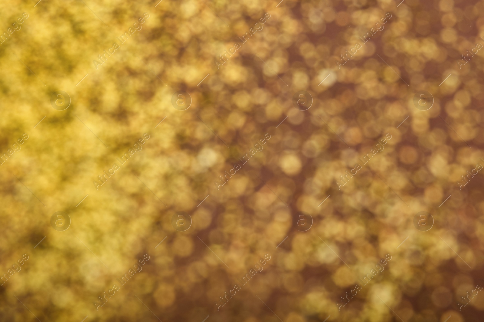 Photo of Blurred view of golden glitter on dusty rose background. Bokeh effect