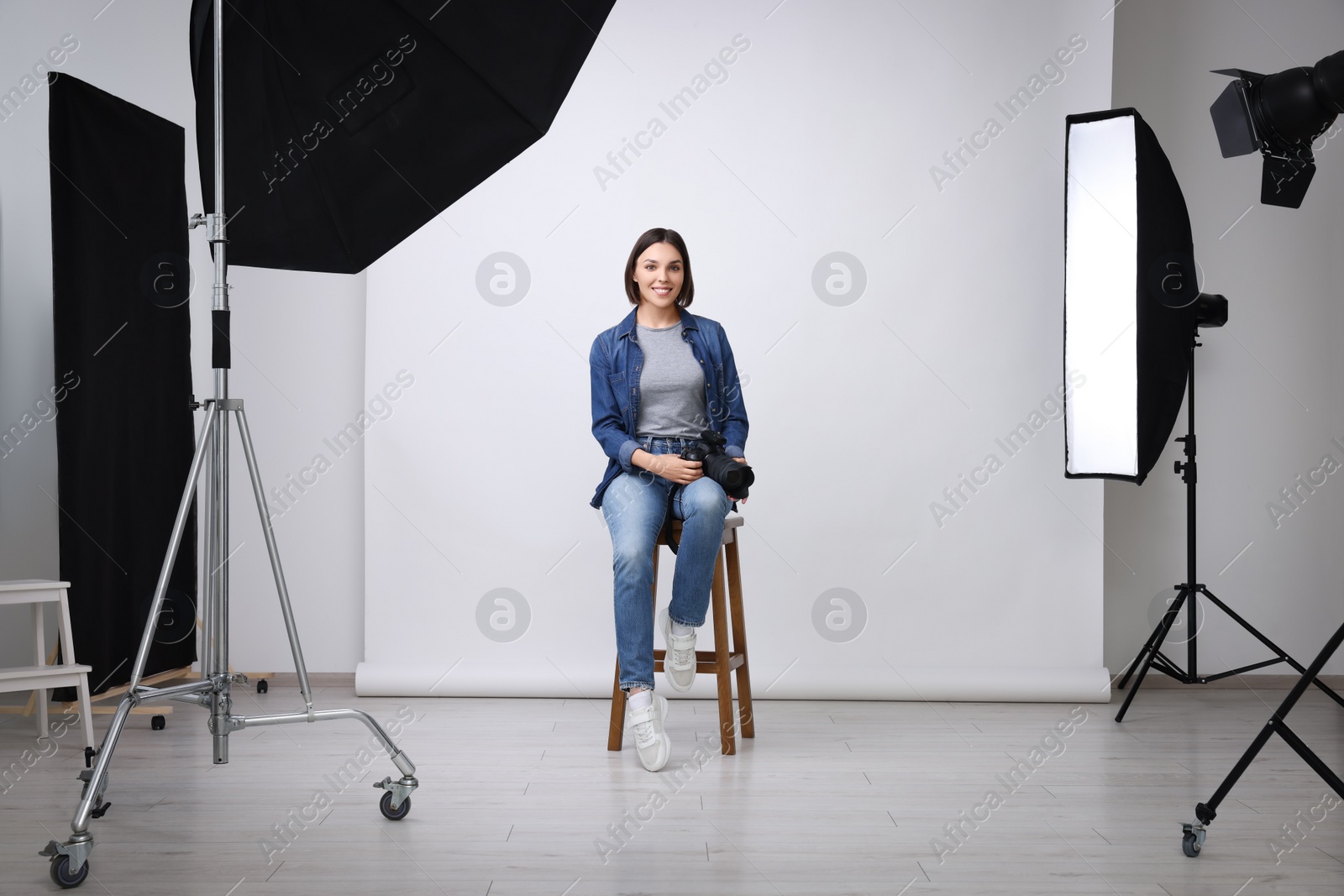 Photo of Professional photographer with camera in modern photo studio