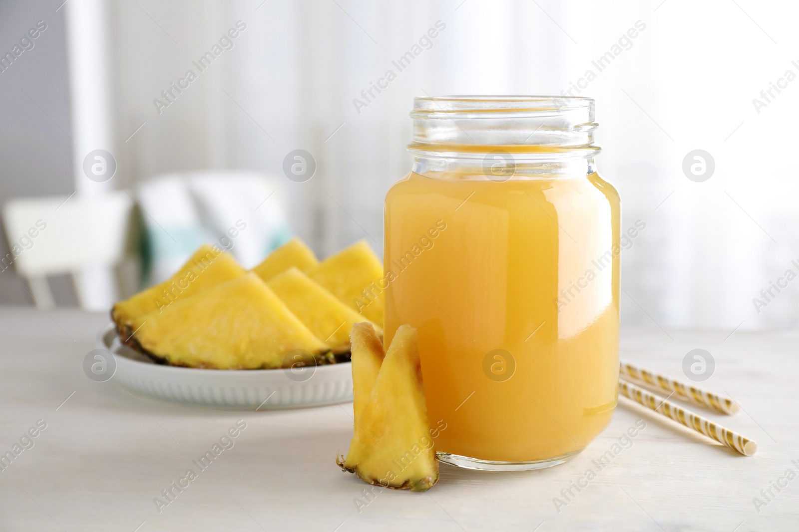 Photo of Delicious pineapple juice and fresh fruit on white table indoors. Space for text