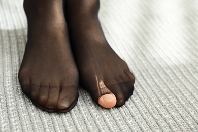 Photo of Woman wearing torn tights at home, closeup