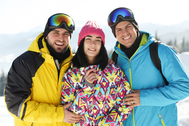 Happy friends on snowy hill in mountains. Winter vacation