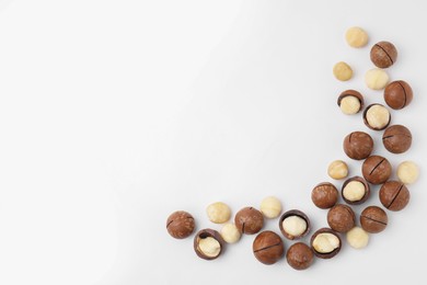 Tasty Macadamia nuts on white background, flat lay. Space for text