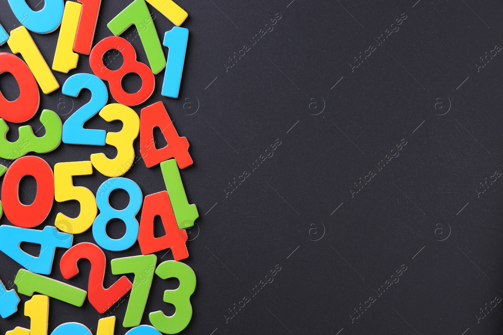 Photo of Colorful numbers on black background, flat lay. Space for text