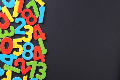 Photo of Colorful numbers on black background, flat lay. Space for text