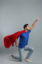 Photo of Man wearing superhero cape on grey background