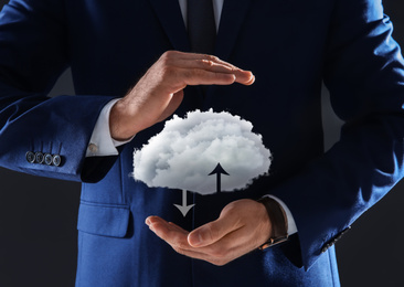 Modern storage technology concept. Man holding cloud on black background, closeup