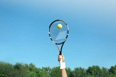 Sportswoman playing tennis outdoors on sunny day, closeup