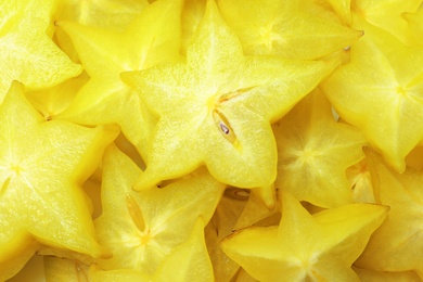 Photo of Pile of delicious carambola slices as background, top view