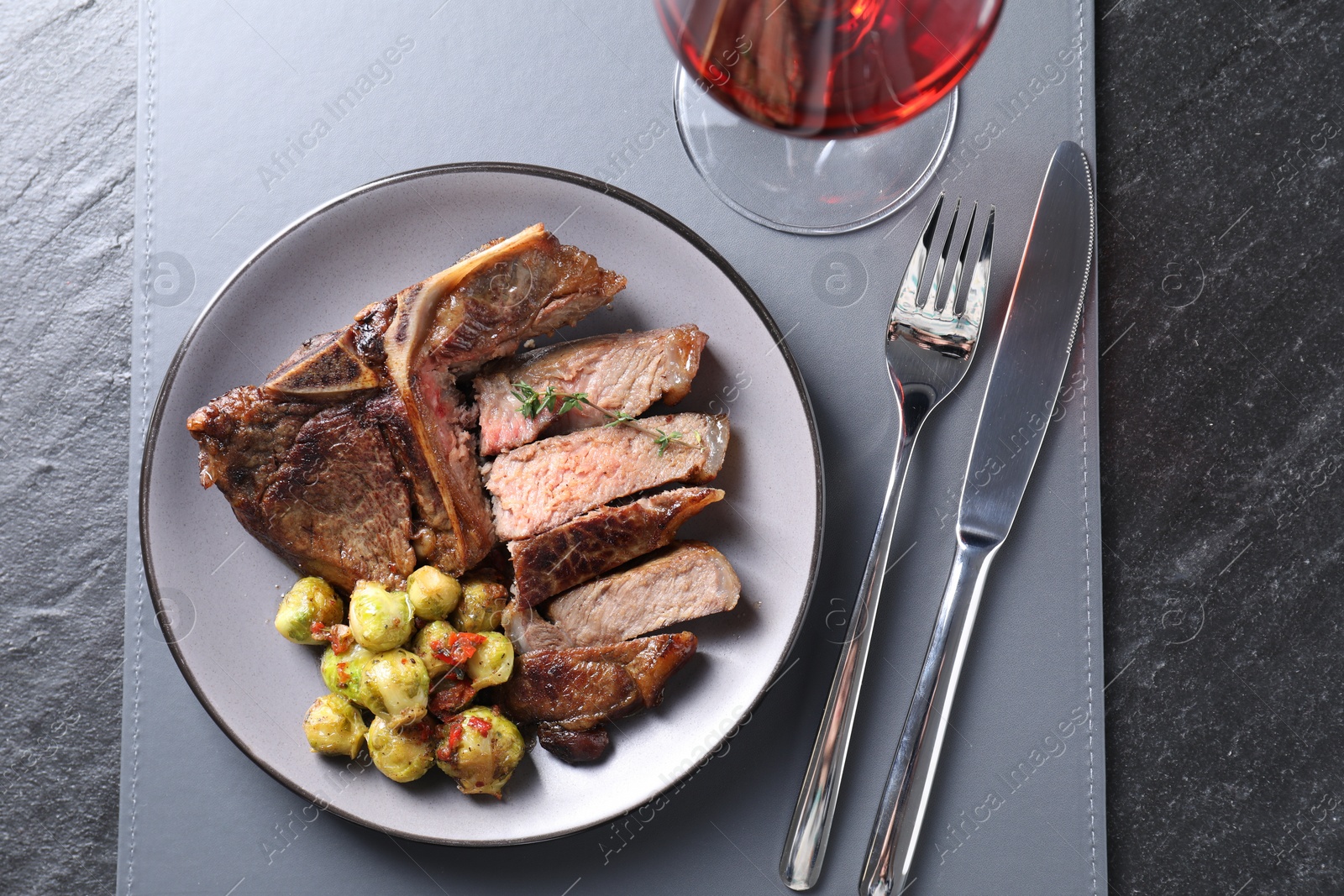 Photo of Delicious fried beef meat and vegetables served on black table, top view