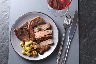 Photo of Delicious fried beef meat and vegetables served on black table, top view