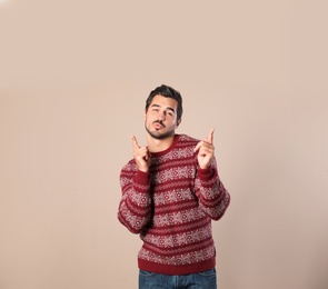 Photo of Portrait of happy man in Christmas sweater on beige background