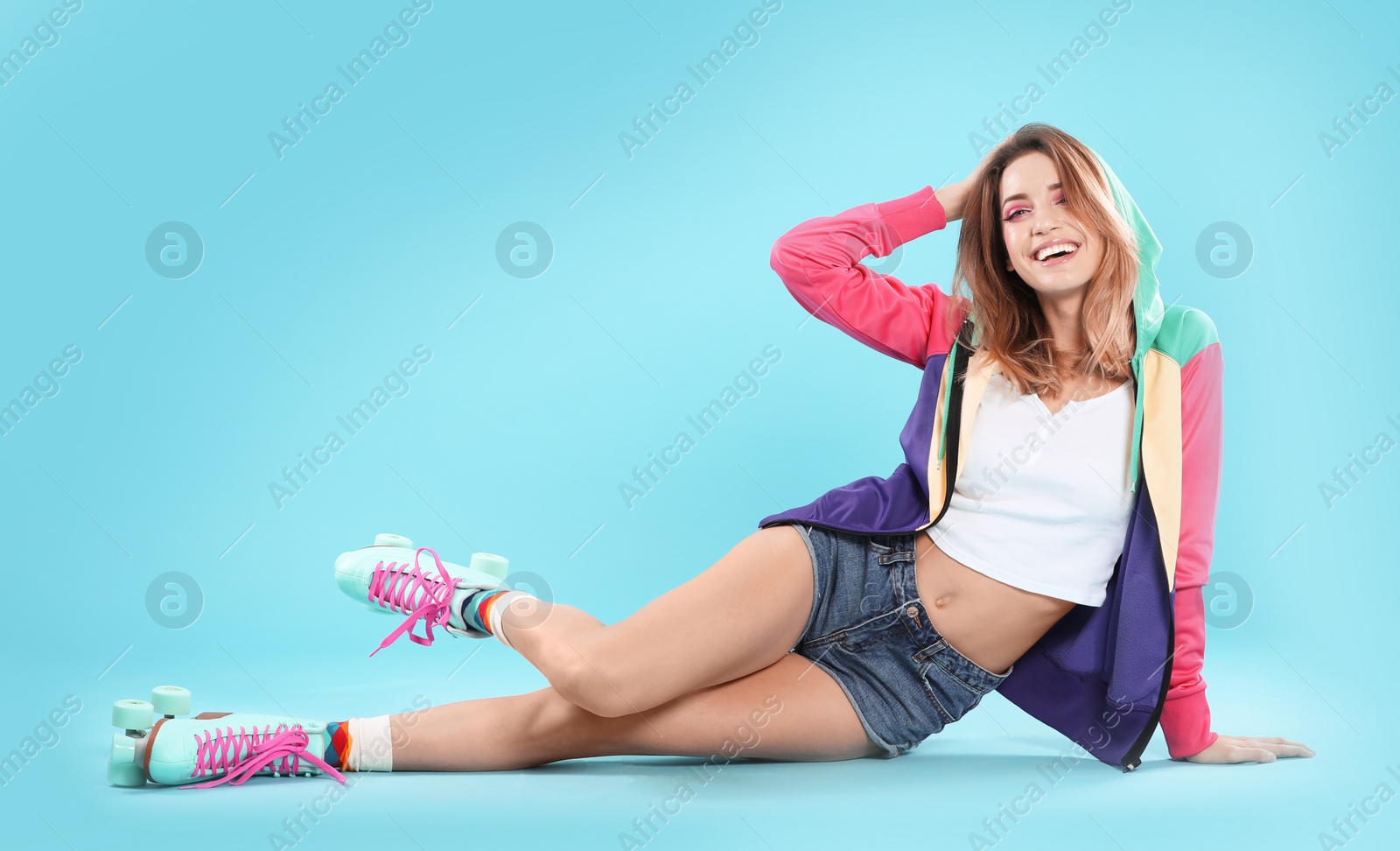 Photo of Young woman with retro roller skates on color background