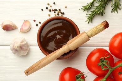 Photo of Flat lay composition with tasty barbeque sauce in bowl on white wooden table