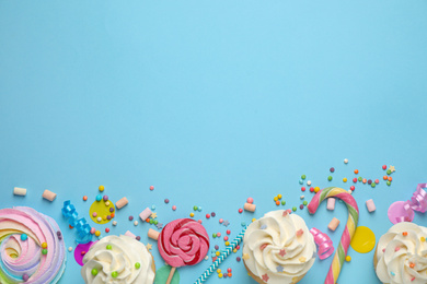 Photo of Flat lay composition with cupcakes on light blue background, space for text. Birthday party