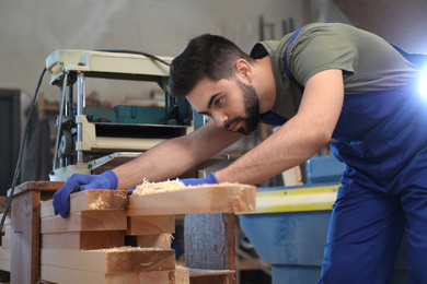 Photo of Professional carpenter working with wood in shop
