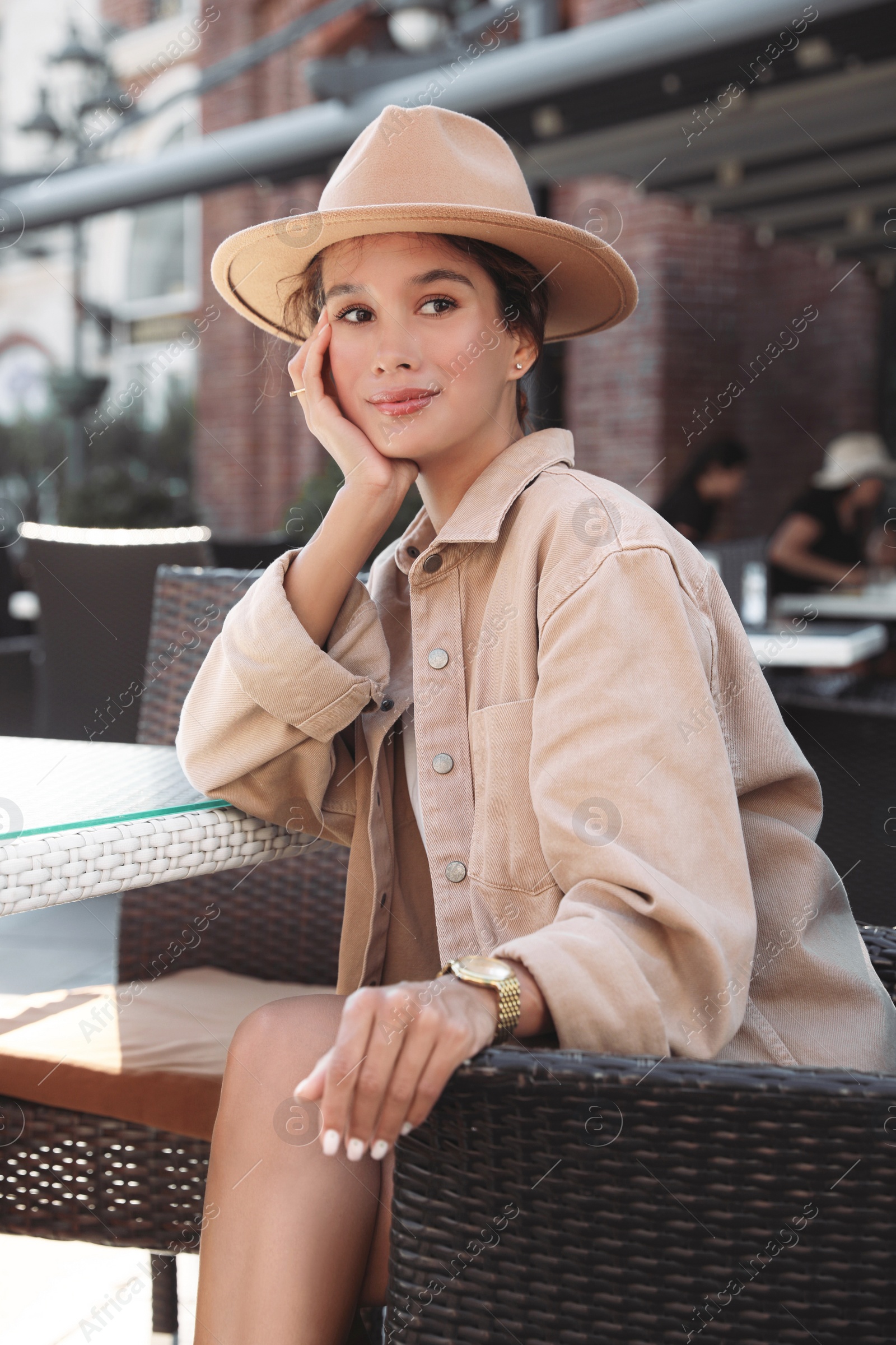 Photo of Portrait of happy young woman in outdoor cafe