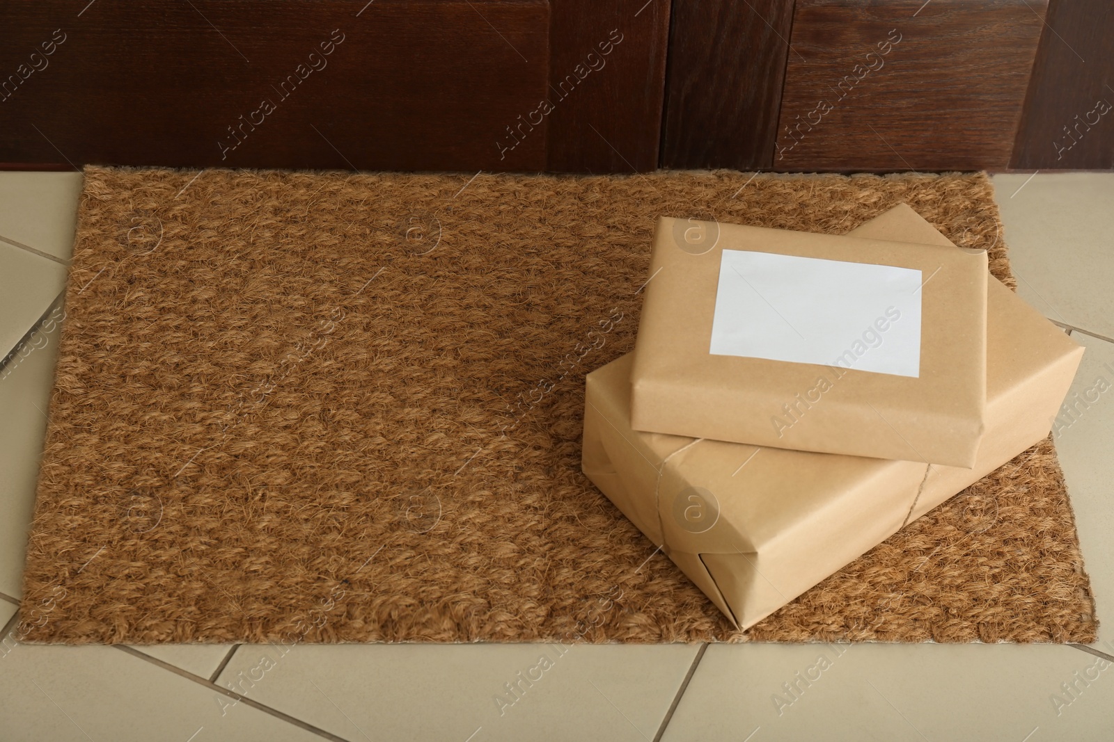 Photo of Parcels on rug near door. Delivery service