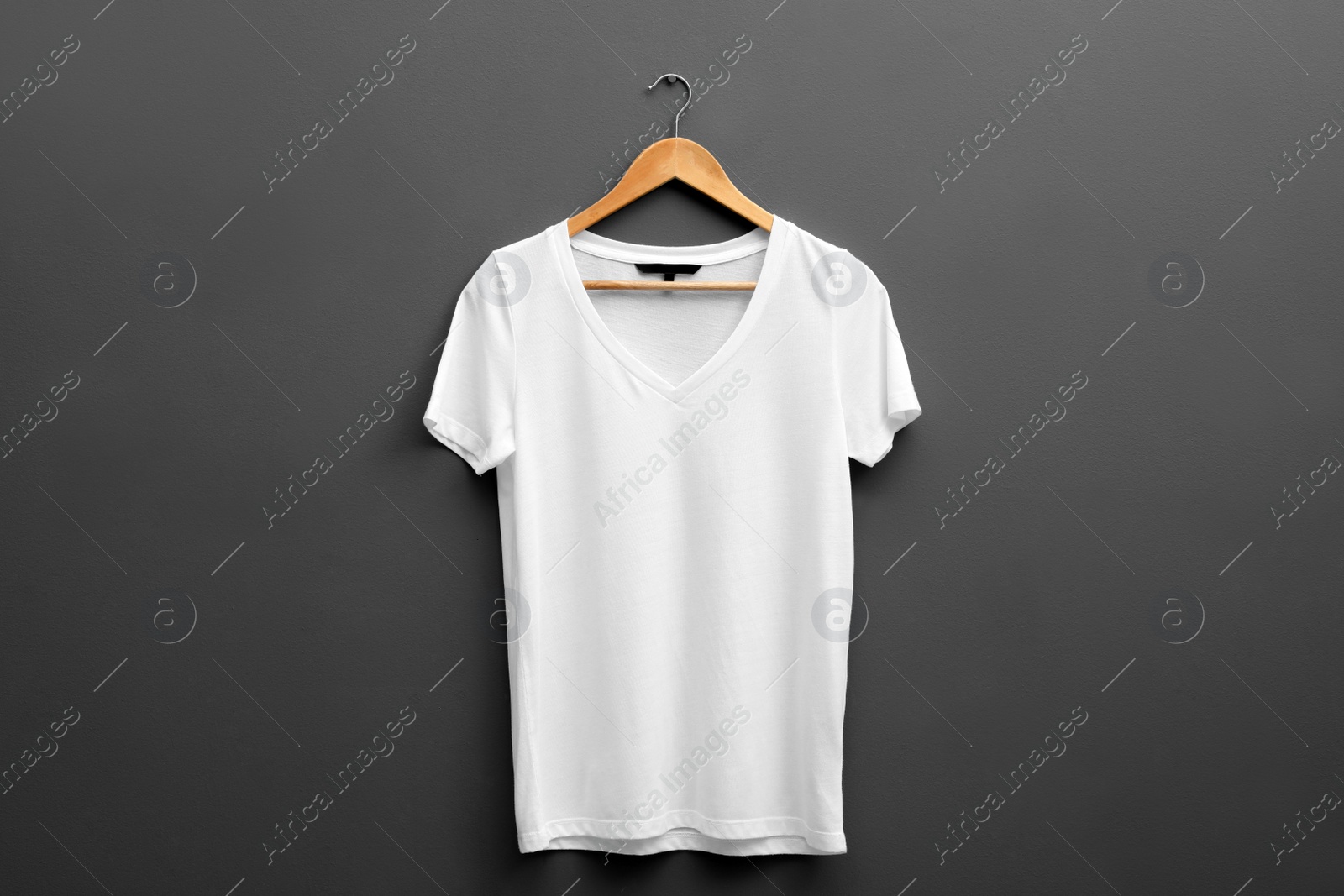 Photo of Hanger with blank t-shirt on grey background. Mockup for design