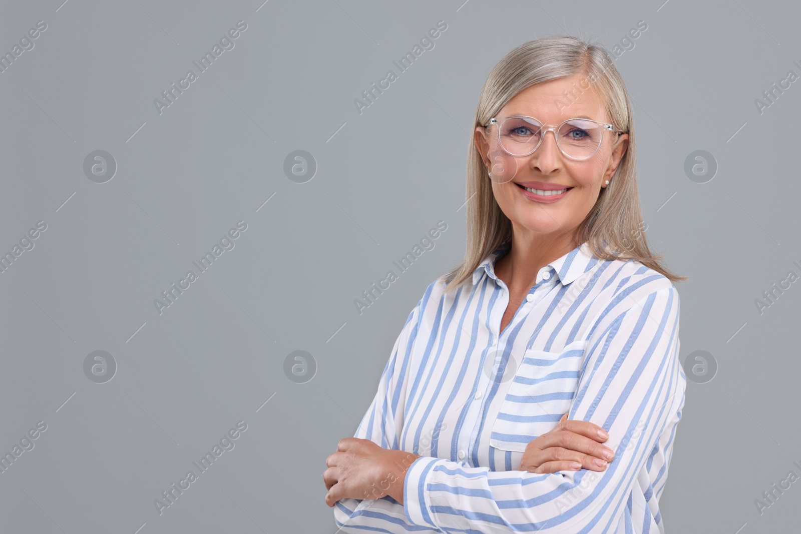 Photo of Portrait of beautiful middle aged woman in eyeglasses on light grey background, space for text