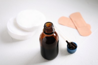 Photo of Bottle of medical iodine, cotton buds and sticking plasters on white table