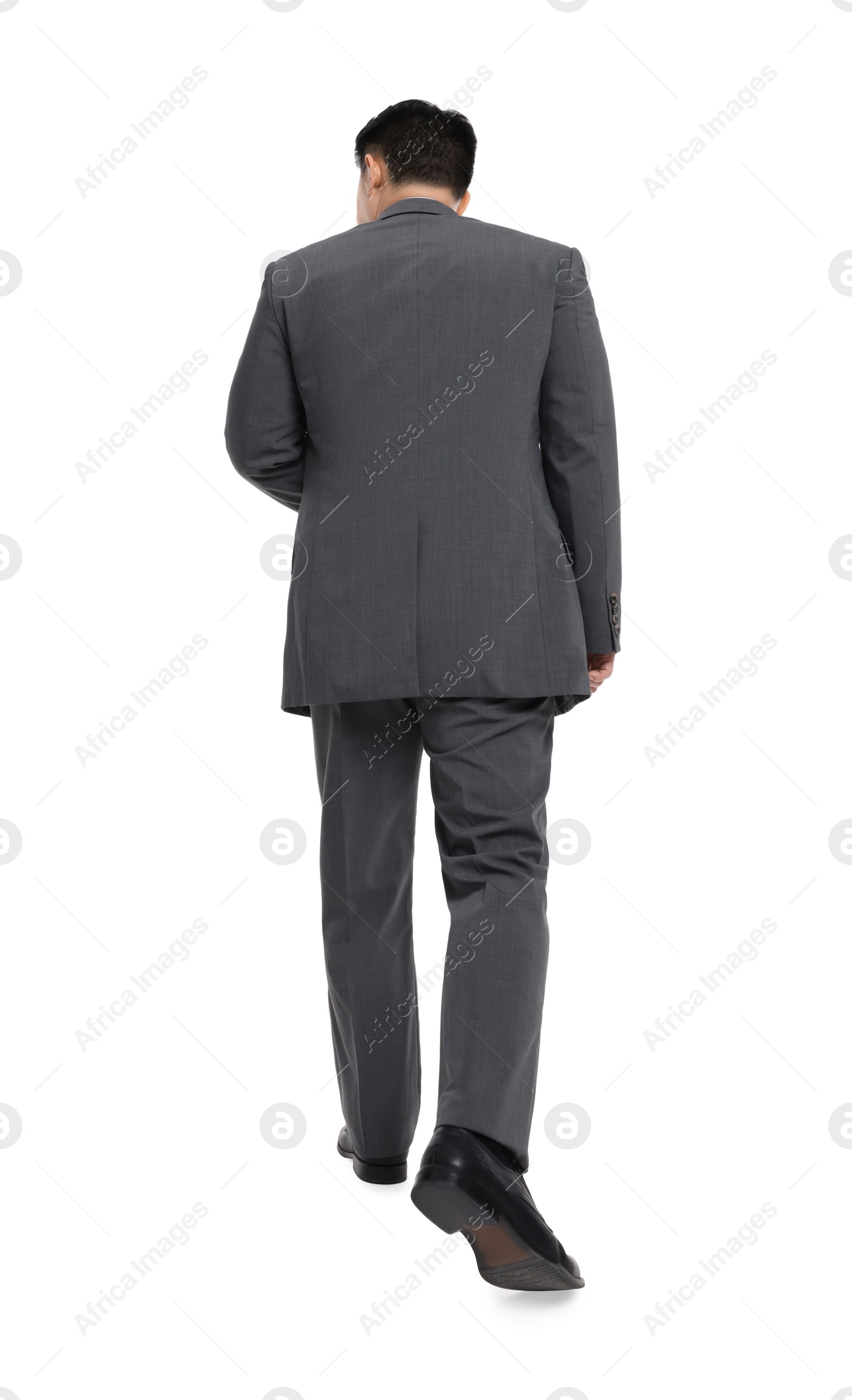 Photo of Businessman in suit walking on white background, back view