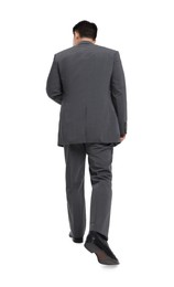 Businessman in suit walking on white background, back view