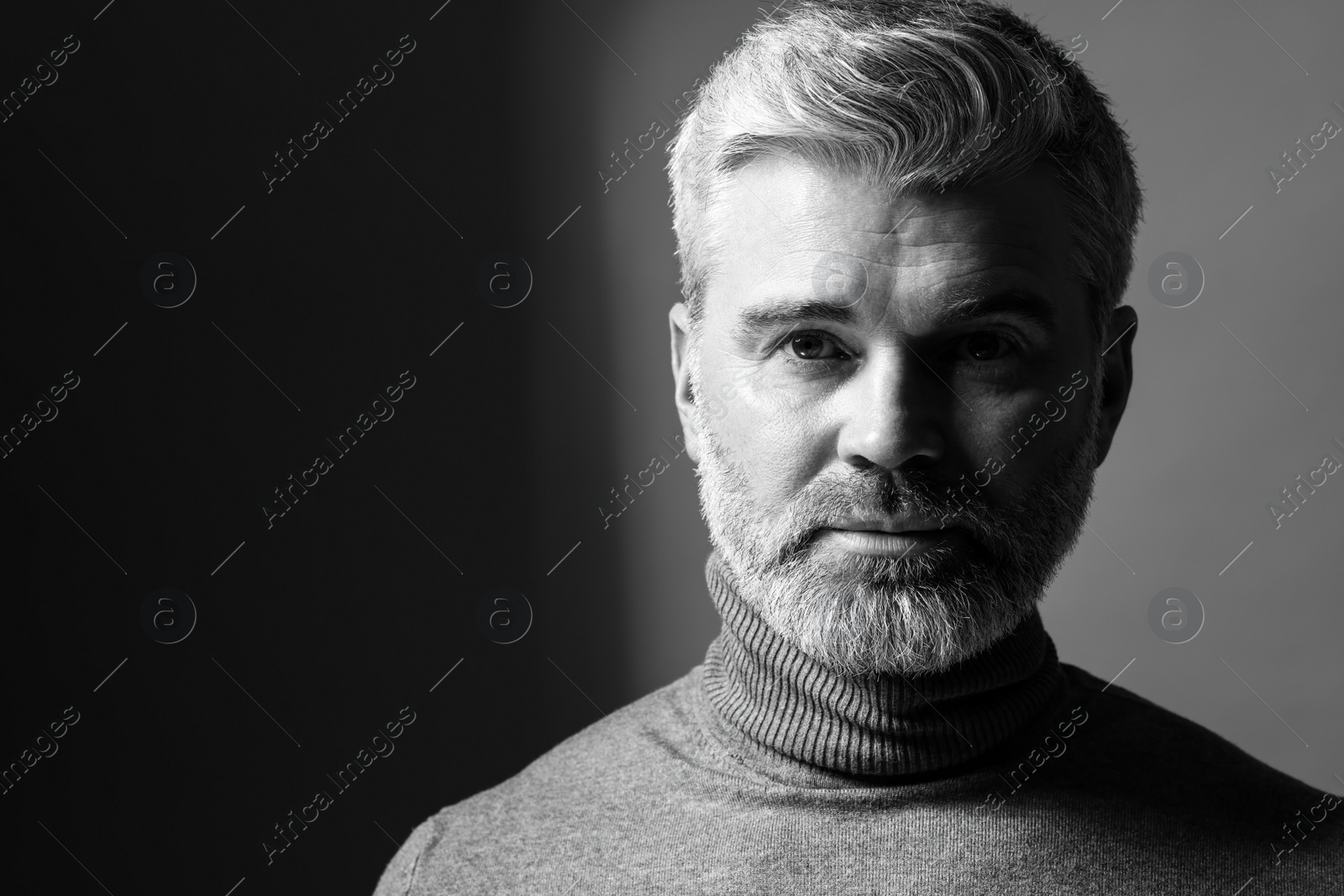 Photo of Portrait of handsome man on dark background, space for text. Black and white effect