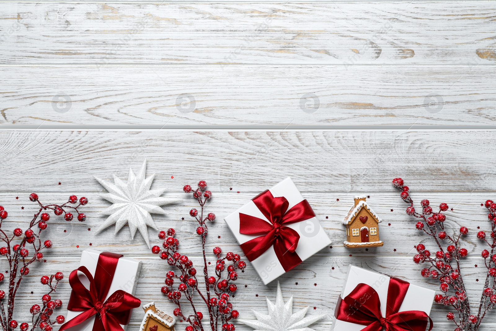 Photo of Flat lay composition with beautiful gift boxes and different Christmas decor on white wooden table. Space for text