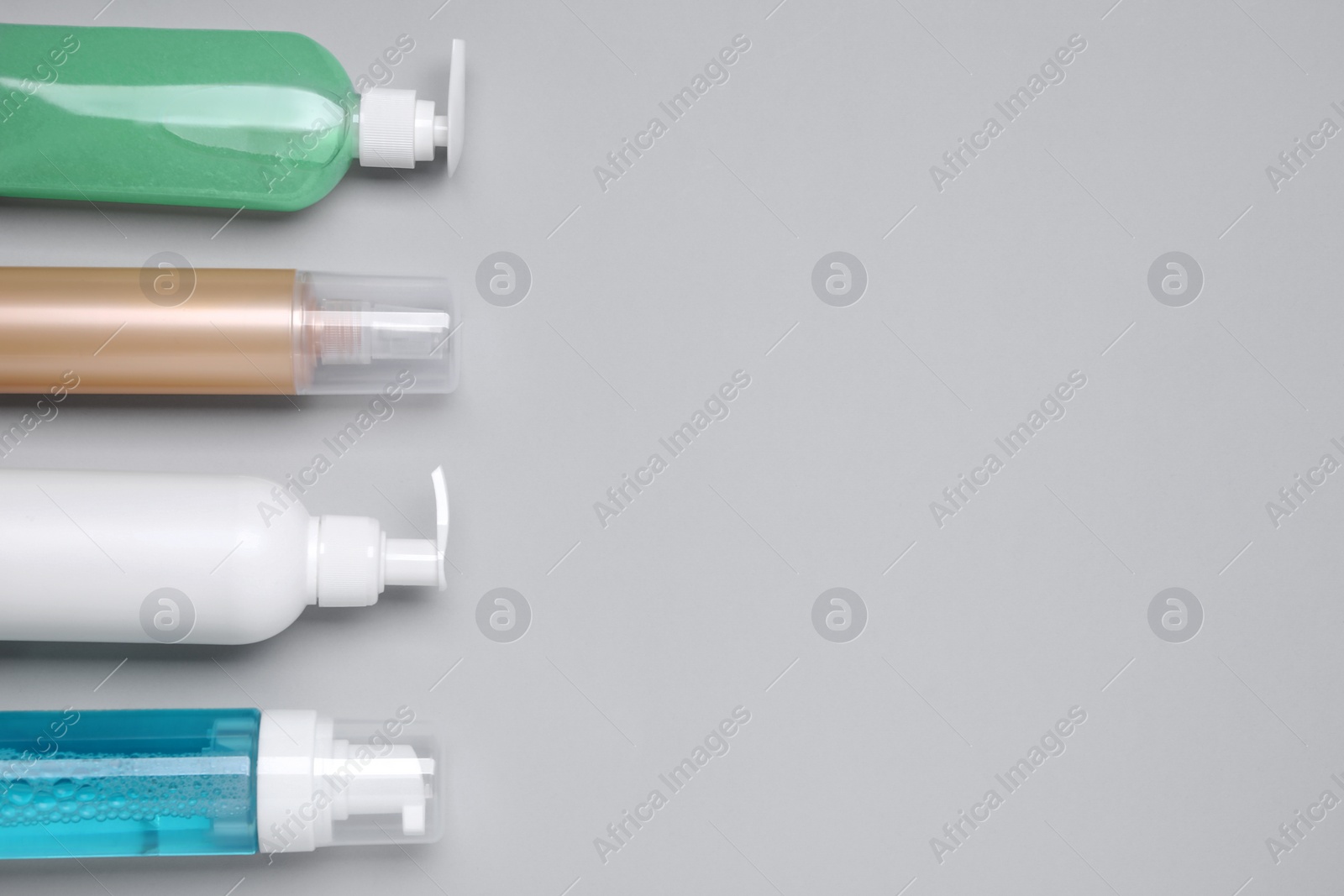 Photo of Different cleansers on light grey background, flat lay and space for text. Cosmetic product