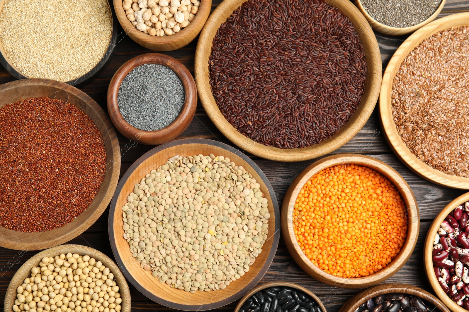 Photo of Different grains and seeds on wooden table, flat lay. Veggie diet