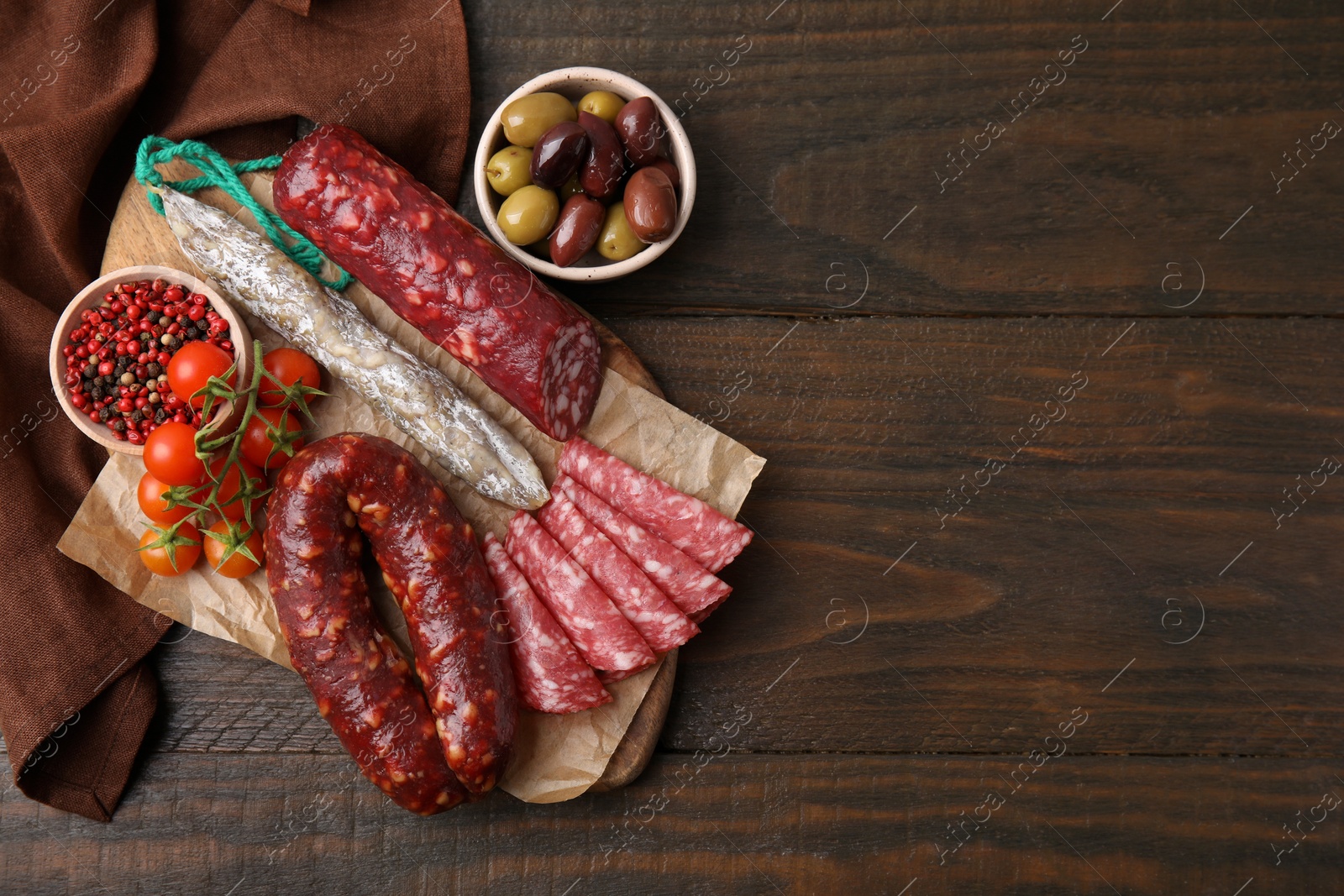 Photo of Different types of tasty sausages on wooden table, flat lay. Space for text