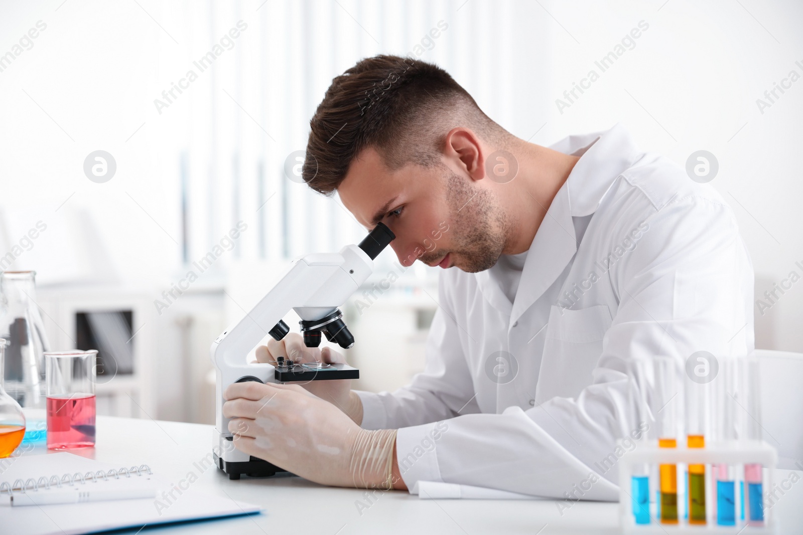 Photo of Scientist using modern microscope at table. Medical research