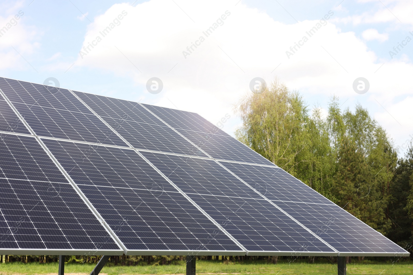 Photo of Solar panels in field on sunny day. Alternative energy